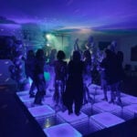 A lively dance party in a room transformed by dramatic lighting and decor.