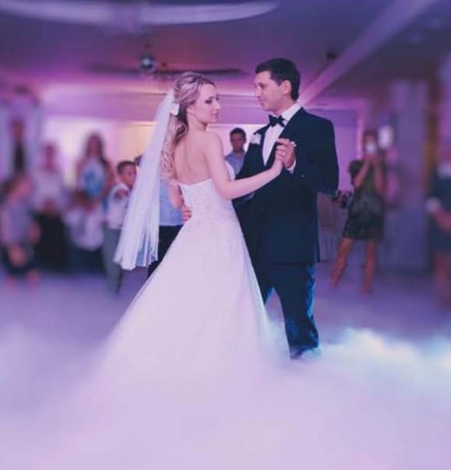 A bride and groom performing their first dance at their wedding reception.