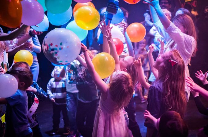 A children's party or event, filled with colorful balloons and a sense of excitement.